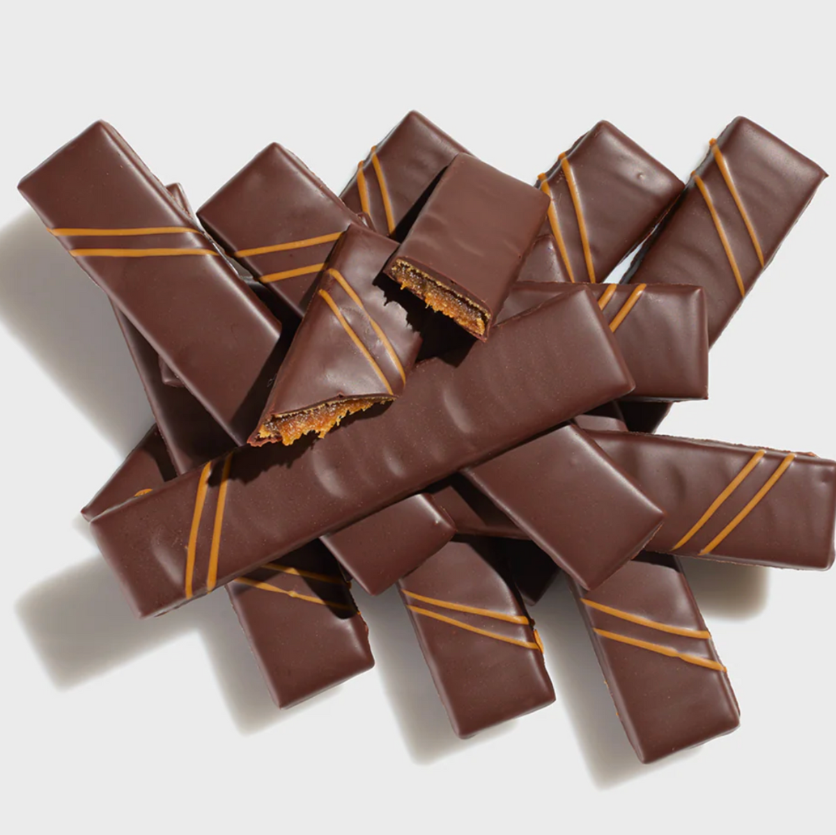 Pile of Butterscotch Caramel Batons on a white background.