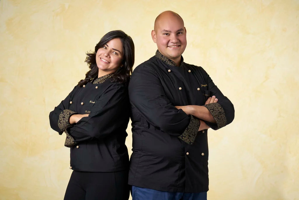 Owners of Aroko chocolate standing back to back on a beige background