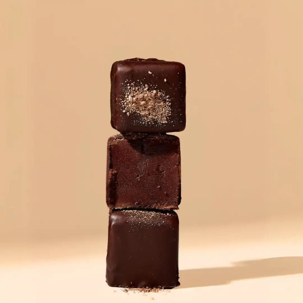Three stacked chocolate cubes on a beige background