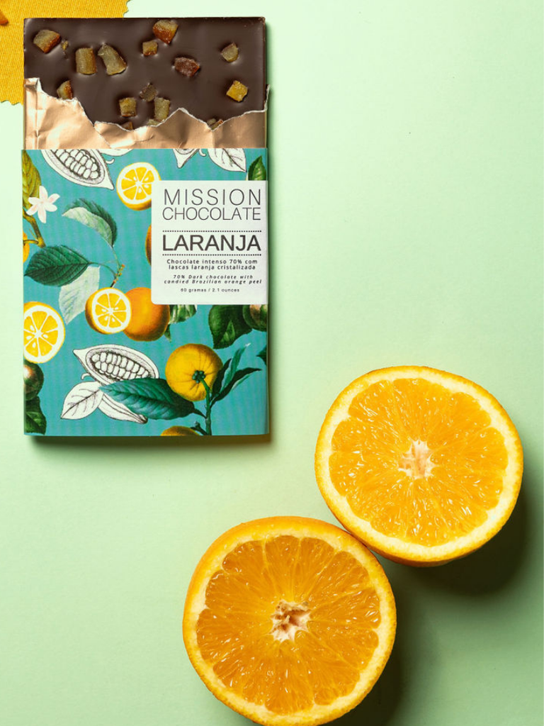 Orange Dark Chocolate 70% bar on a green table with two orange halves