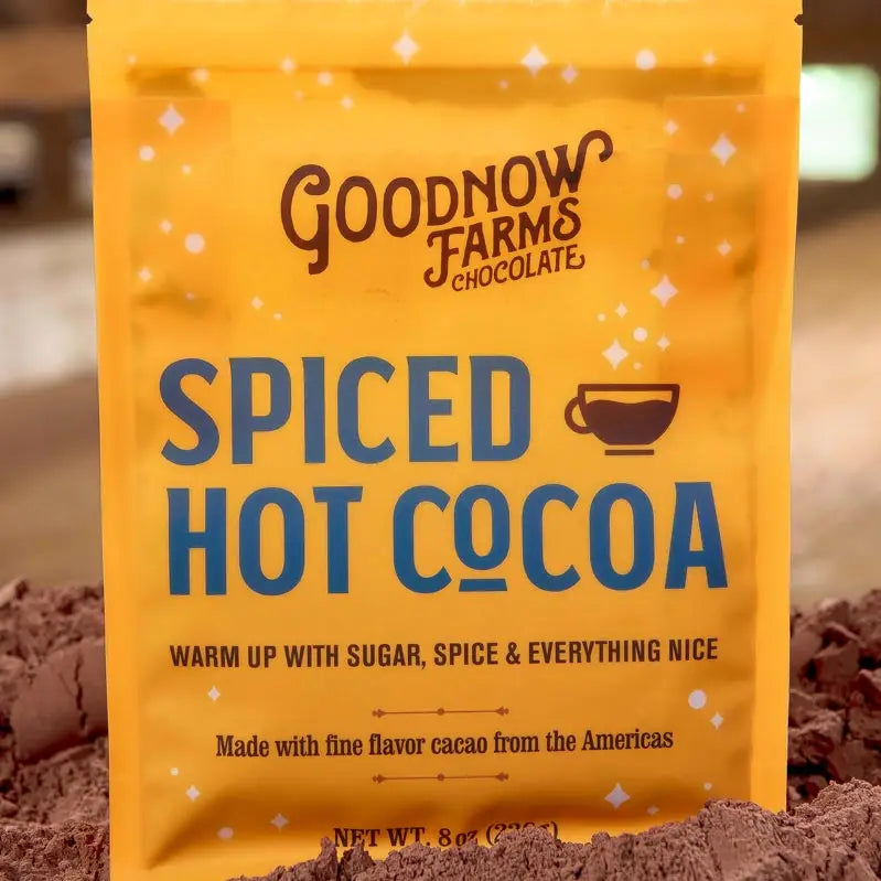 Good Now Farms spiced hot cocoa packaging in a pile of raw cocoa