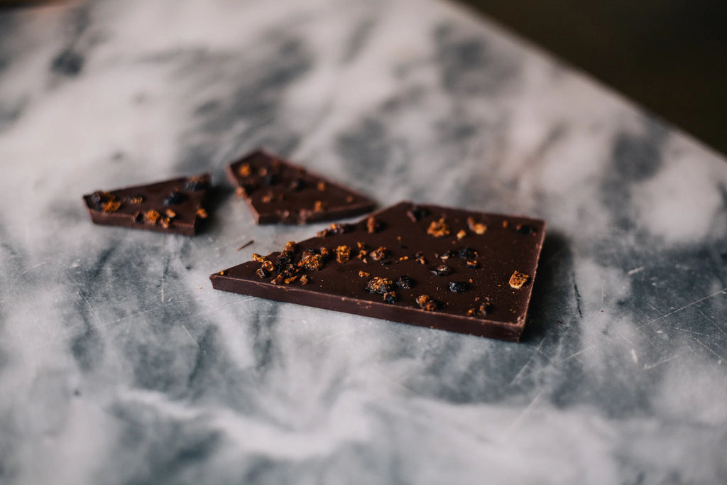Unwrapped pieces of Black Fig 72% on a marble table