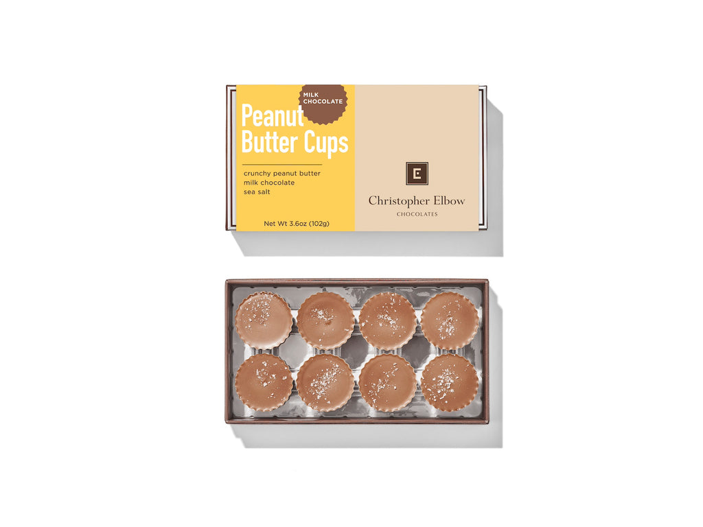Wrapped and unwrapped Milk Chocolate Peanut Butter Cups from Christopher Elbow, against a white background.