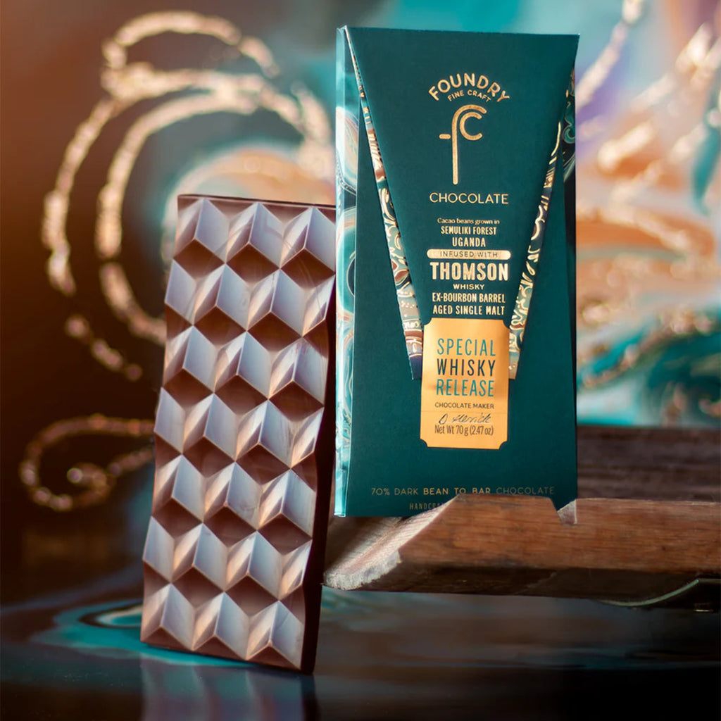 Foundry Limited Edition Whiskey chocolate bar against a geometric pattern and packaging on a decorative background