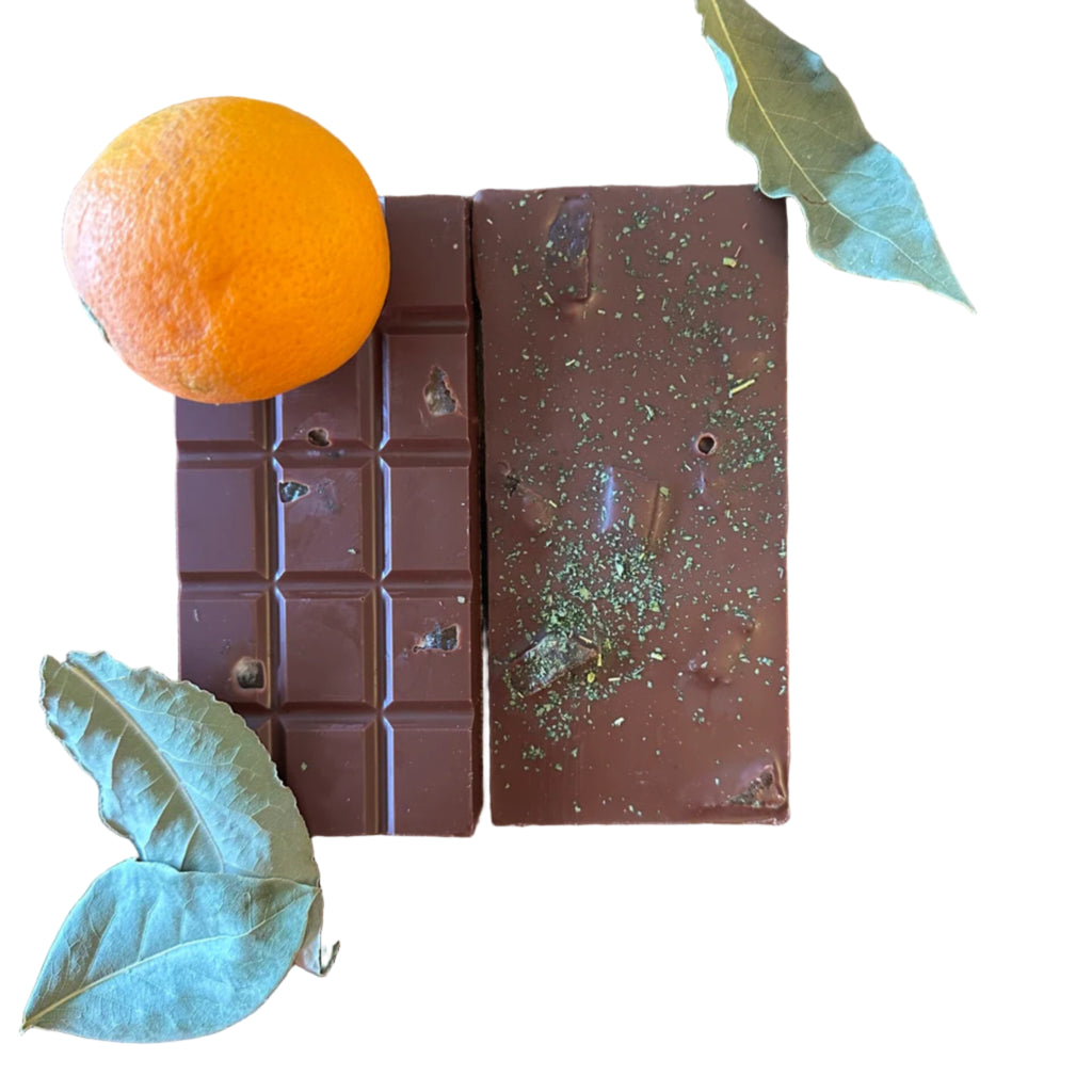 Ember Chocolate Covered Oranges chocolate bar with oranges and herbs on a wooden surface