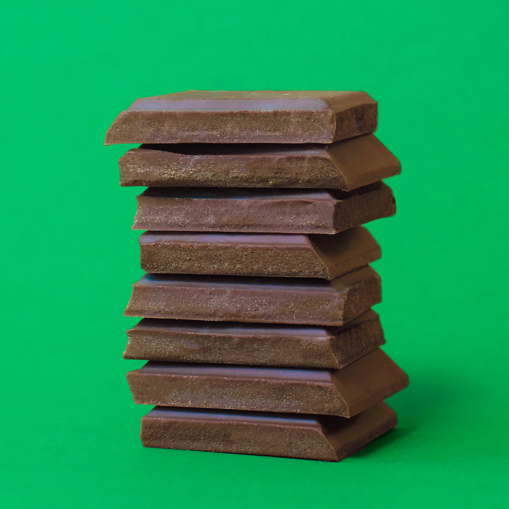 Unwrapped, stacked Magical Mint Bars against a green background