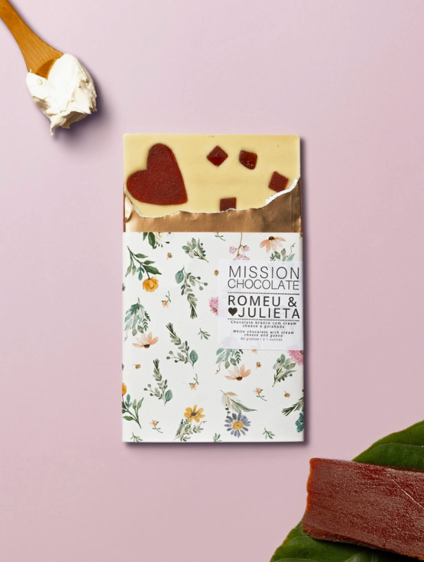 Partially opened Romeu & Julieta bar on a light pink table with ingredients