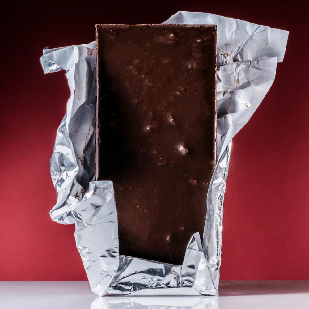 Unwrapped 80% Pure Cacao with Strawberry & Coconut against a red background