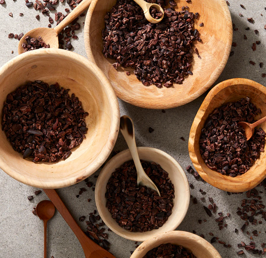 Wooden bowls of Roasted Cacao Nibs from Xocolatl on a grey table