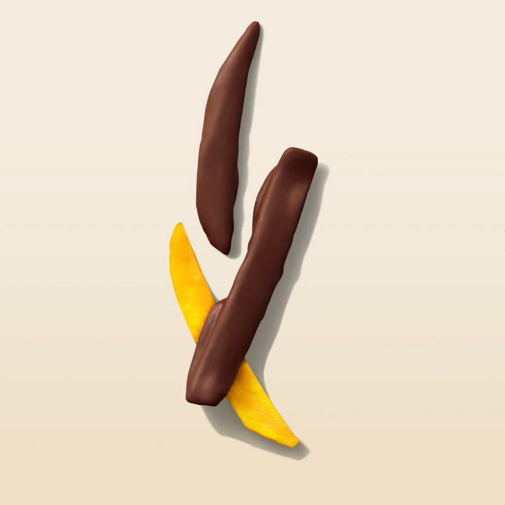 Chocolate-covered mangoes on a beige background
