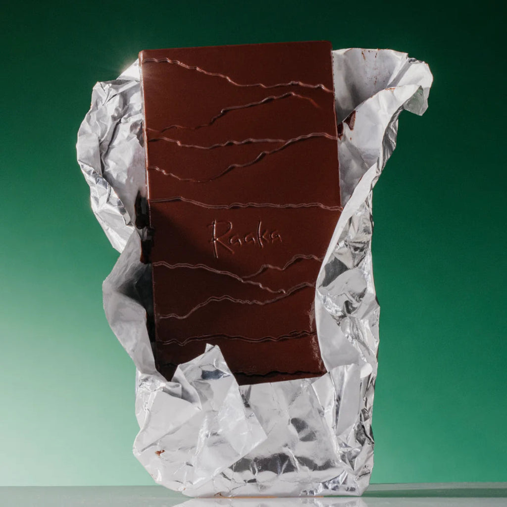 Chocolate bar in a crumpled wrapper on a green background
