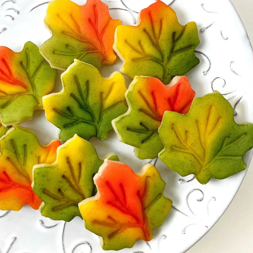 Gourmet Marzipan Autumn + Thanksgiving Maple Leaves CandyLeaf-shaped cookies in autumn colors on a decorative plate