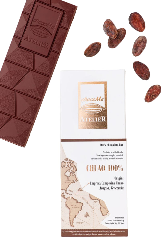 ChocoMe Ateleier Chuao 100% chcooate bar and packaging with cacao beans against a white background
