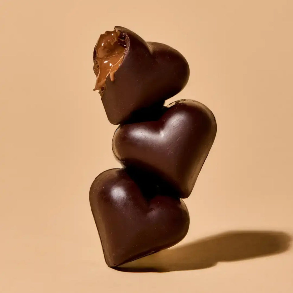 Stack of chocolate hearts on a beige background