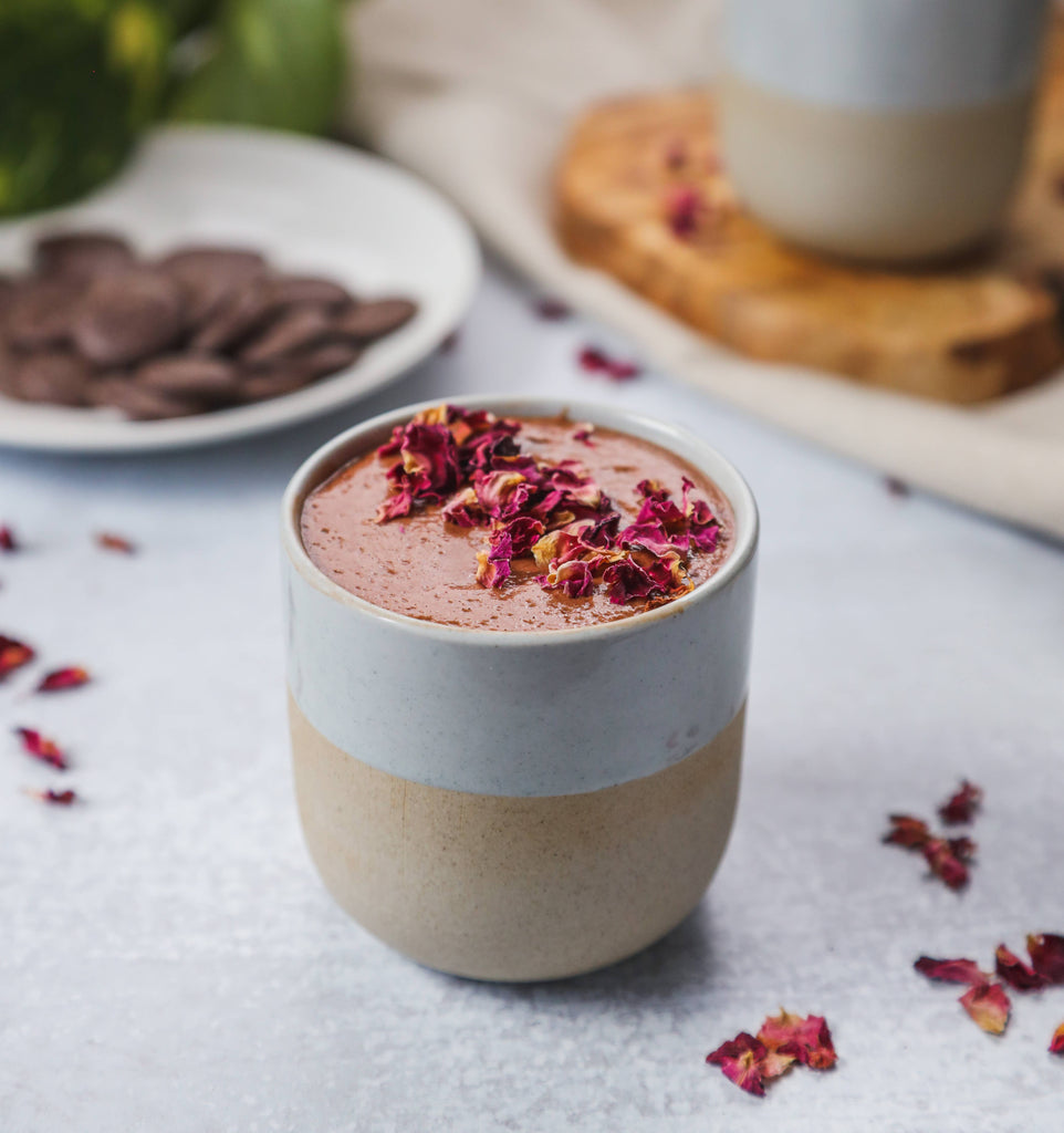 A cup of drinking chocolate made with Tantric Rose Blossom Enhanced Organic Ceremonial Cacao