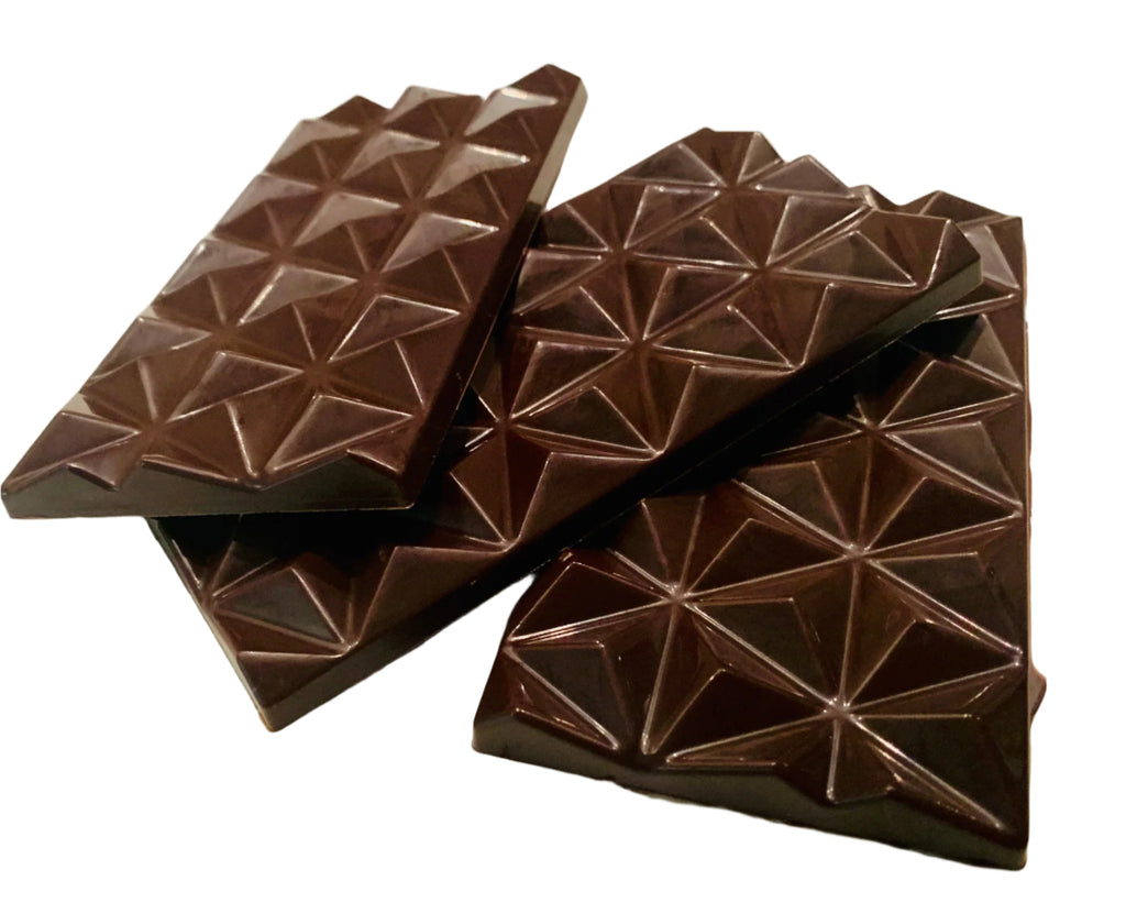 Three unwrapped Hazelnut Dark Chocolate 55% bars from The Organic House against a white background