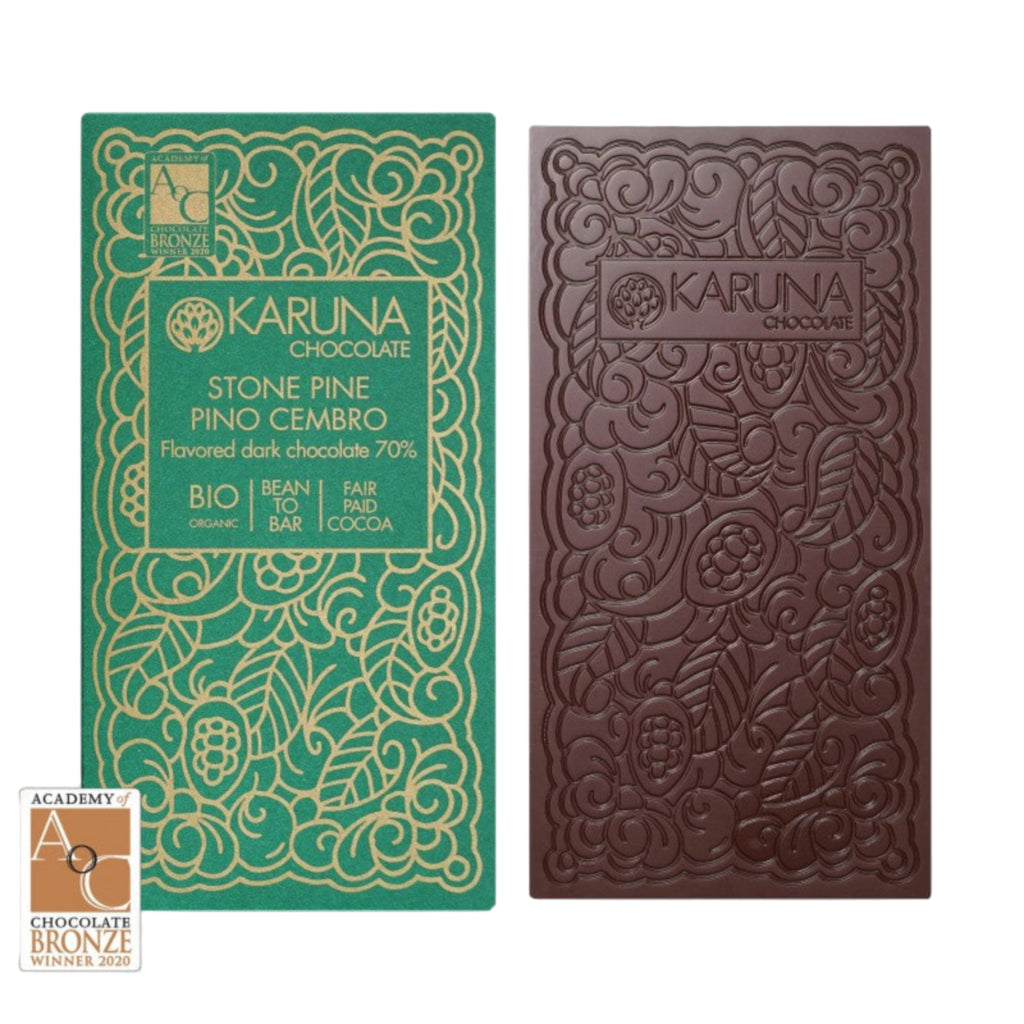 Karuna stone pine 70% chocolate bar with decorative packaging on a white background